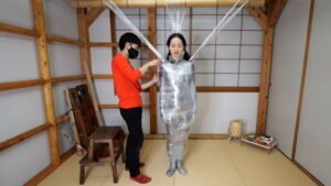 Fetish mummification for Hinako with Plastic Wrap creating a spider web style Part 1