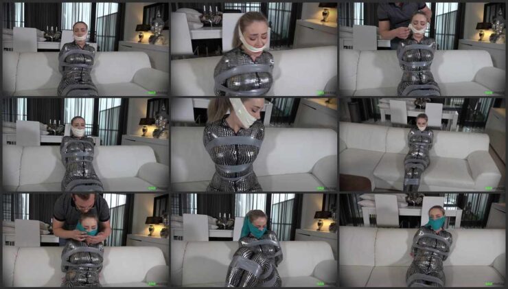 Aubrey is dressed in a catsuit , tied up with tape and cheerfully takes a few gags