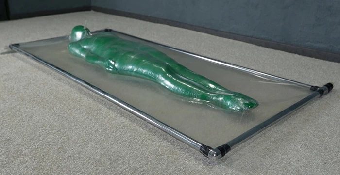 Transparent mummification of a green man in a vacuum bed