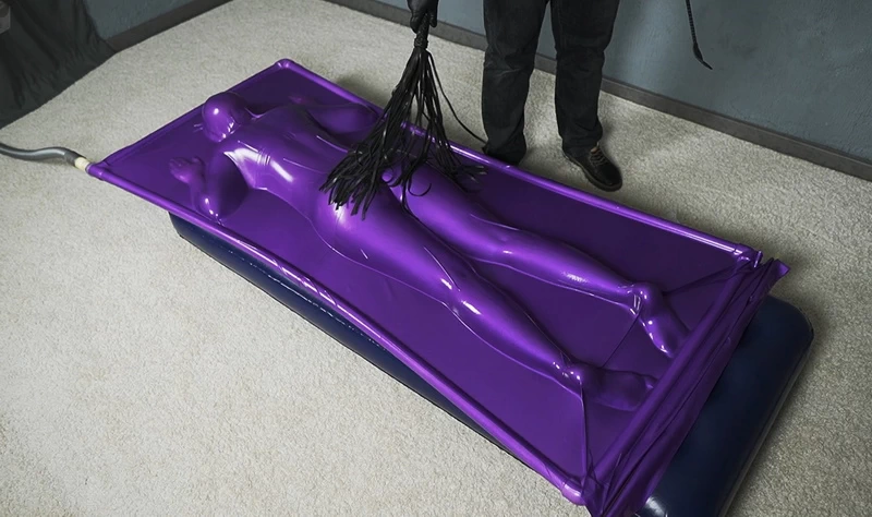 Butt flogging on a mattress in a purple vacuum bed
