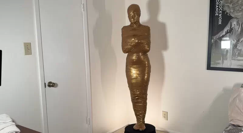 Trophy Girl: Calisa Becomes a Golden Mummy Statue